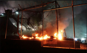 ANGRY migrants at Greek refugee camp have reportedly started a fire after a gas explosion killed a mother and a six-year-old child, local media report…